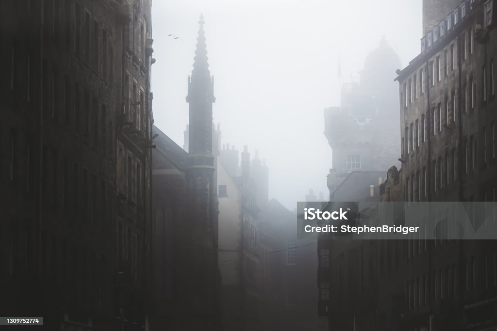 Moody Royal Mile. Edinburgh, Scotland Haunting, spooky and moody atmospheric old town Edinburgh along the medieval Royal Mile in misty fog. Edinburgh - Scotland Stock Photo