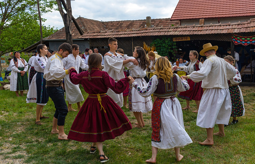 Salaj, Transylvania, Romania- May 15, 2018: Young people dressed in Romanian folk costumes having fun and dancing at a traditional country fair in Marin village, Salaj county