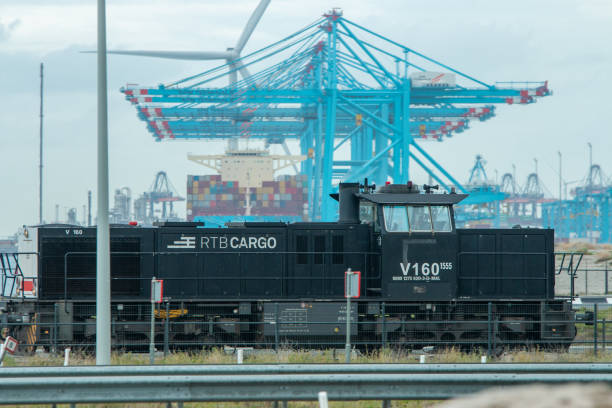 Port Rotterdam Maasvlakte, port Rotterdam, The Netherlands - October 22 2020: freight train passing heavy lift cargo cranes moving cargo containers from shipping onto trucks tasrail stock pictures, royalty-free photos & images