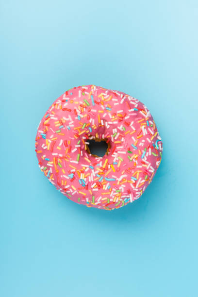 istock Fresh made Donuts isolated on blue background. Doughnuts are traditional sweet pastries. Copy space for text. 1309754728