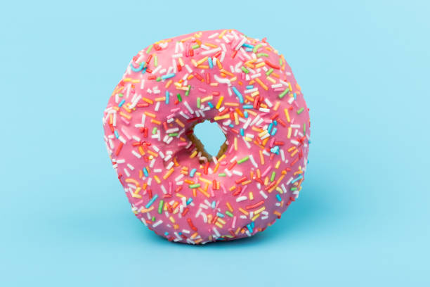 istock Fresh made Donuts isolated on blue background. Doughnuts are traditional sweet pastries. Copy space for text. 1309754915
