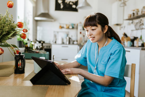 Healthcare worker on video call with a patient Photo series of a day in the life of a healthcare worker at home doing different things. female nurse photos stock pictures, royalty-free photos & images