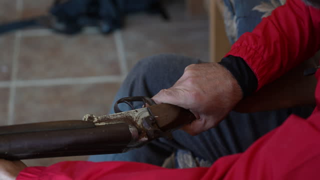 Man holding old fashioned brown and metallic shotgun