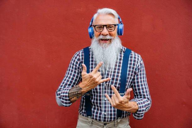 homme barbu aîné bel avec le sourire de casque - men smiling headphones individuality photos et images de collection