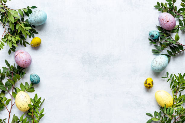 istock Frame of Easter eggs with spring branches and green leaves. Veiw from above 1309756387