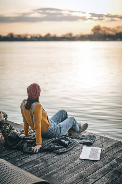 istock Woman sitting on deck and enjoying the view 1309757610