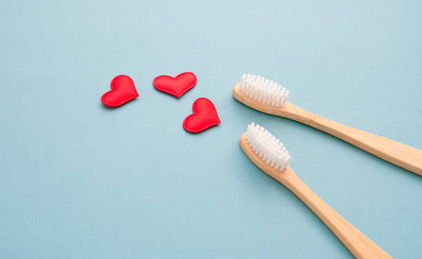 istock Two bamboo toothbrushes close-up and red hearts 1309757975