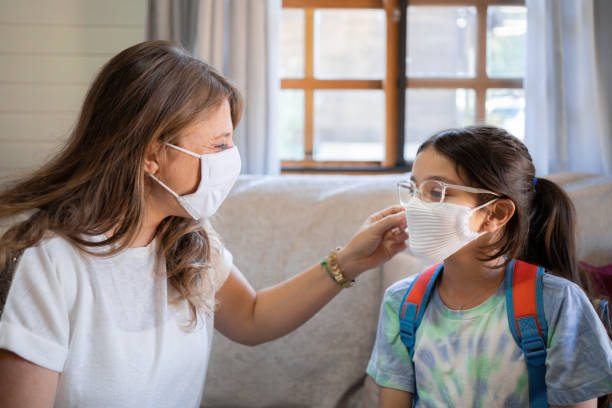 istock Mother and daughter getting ready for school with protective face mask during Covid-19. New normal. 1309764142