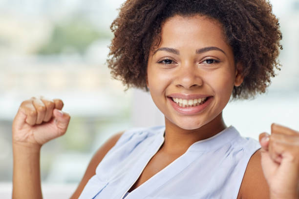 istock happy african young woman with raised fists 1309764183