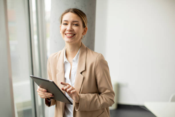 istock Young woman holding digital tablet in modern office 1309764801