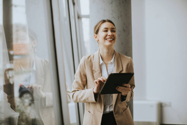 istock Young woman holding digital tablet in modern office 1309764803