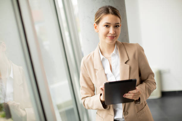 istock Young woman holding digital tablet in modern office 1309764805
