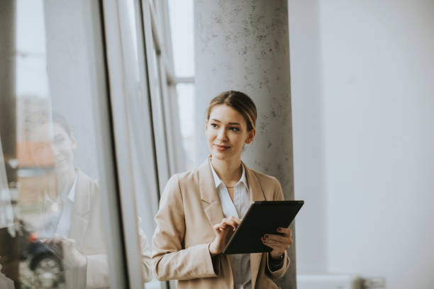 istock Young woman holding digital tablet in modern office 1309765316
