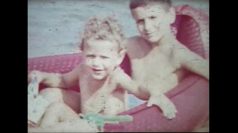 Three children on plastic boat in the sea in 1959 8mm FDV