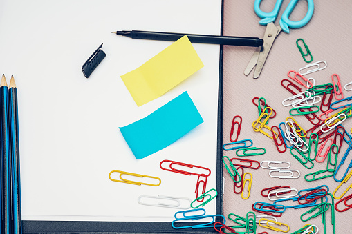 School stationery set, office sticky notes, pen, scissors and colorful paperclips. Horizontal photo