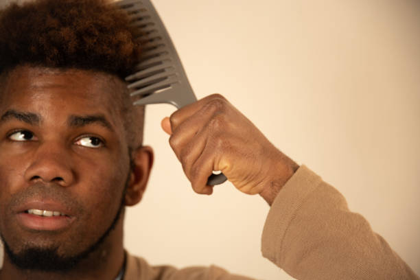 istock Young man combing his hair at home 1309766776
