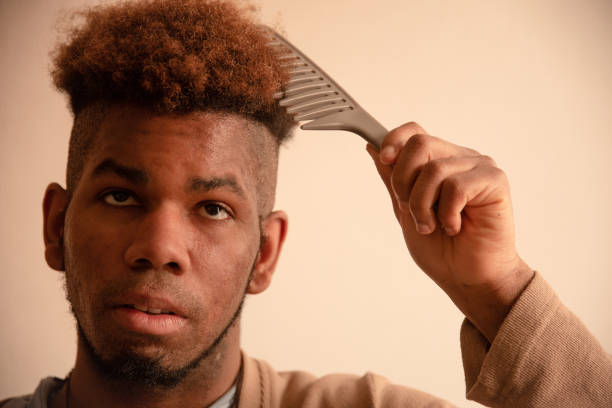 istock Young man combing his hair at home 1309766777