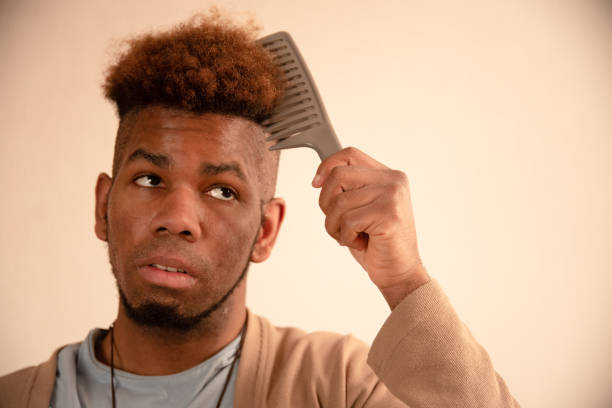istock Young man combing his hair at home 1309766778