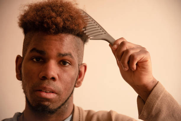 istock Young man combing his hair at home 1309766780