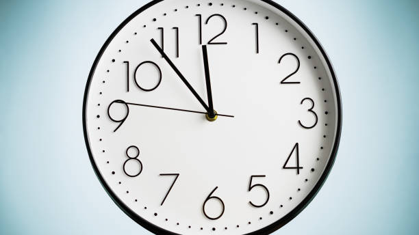 istock Analog white wall clock on green background. Clock in closeup. 1309766889