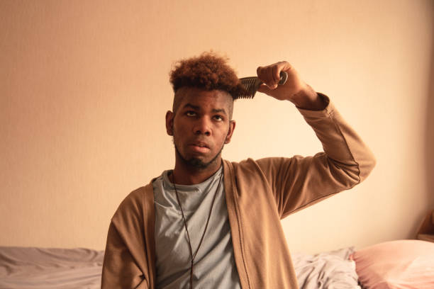 istock Young man combing his hair at home 1309766904