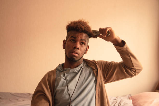istock Young man combing his hair at home 1309766909