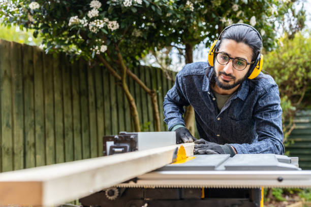 istock Operating electric sawing machine. Young independent home business owner doing environmental woodworking using recycled materials for furniture. 1309768562