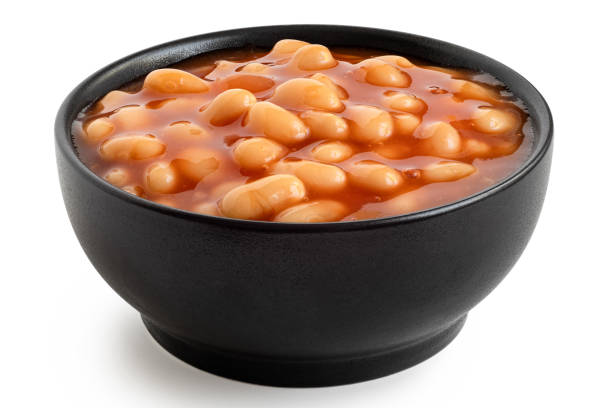 Baked beans Baked beans in tomato sauce in a black ceramic bowl isolated on white. baked beans stock pictures, royalty-free photos & images