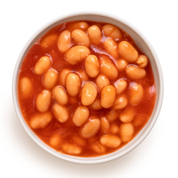 Baked beans Baked beans in tomato sauce in a white ceramic bowl isolated on white. Top view. baked beans stock pictures, royalty-free photos & images