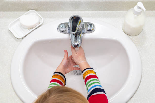 istock Child washing hands with soap in the bathroom 1309770899