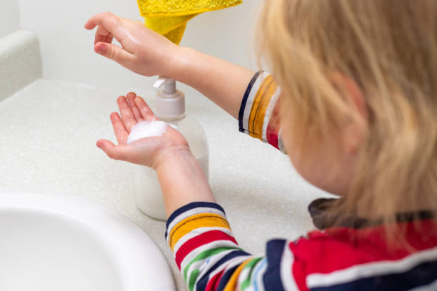 istock Child washing hands with soap in the bathroom 1309770904