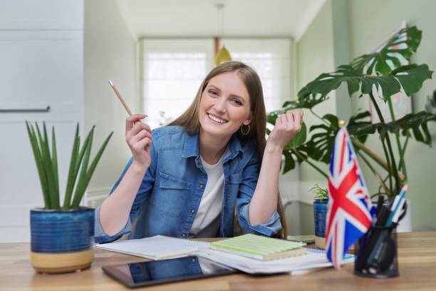 UK learning English online. Female student remotely looking at webcam
