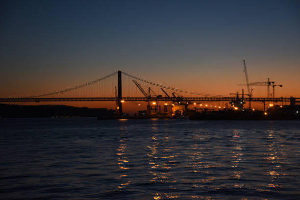 sunset in lisbon with april 25th bridge silhouette in portugal.