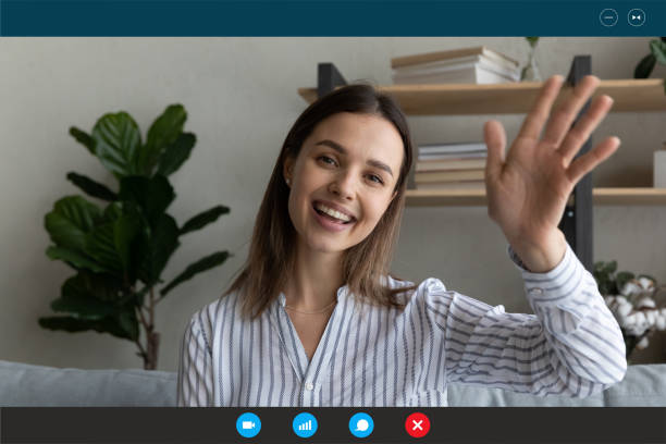 istock Relaxed smiling young woman making hello gesture starting distant conversation. 1309773543