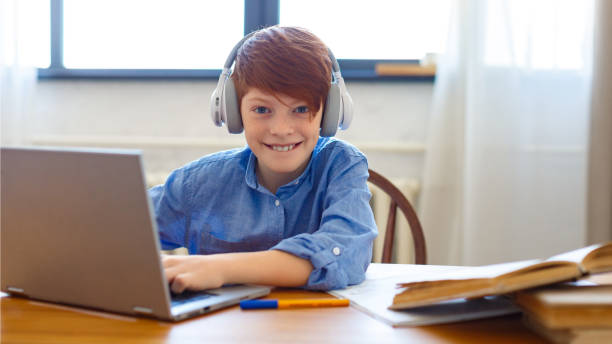 istock Red-haired boy during an online video call with friends. He writes messages and communicates online 1309773878