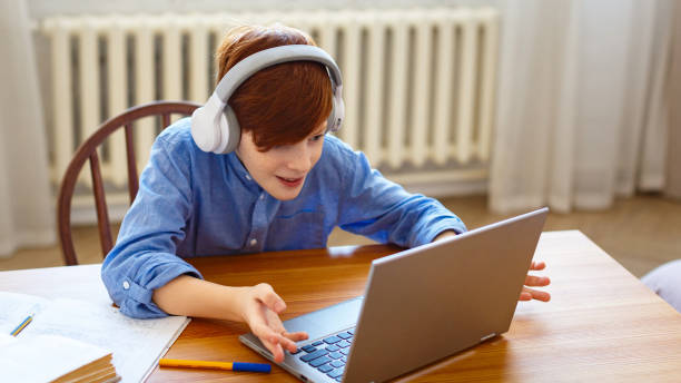 istock Red-haired boy during an online video call with friends. He actively gestures during communication 1309773947