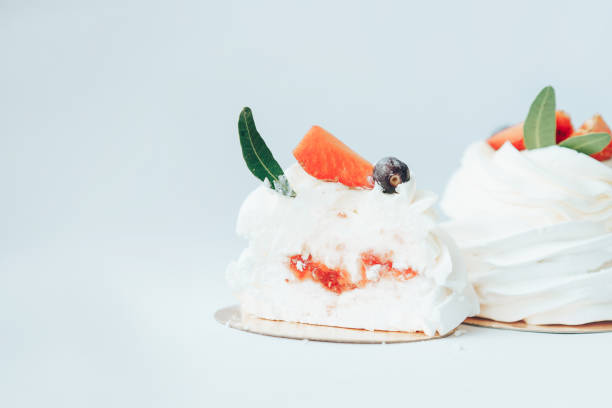 Delicious cakes covered with white and berry cream standing in row against white background