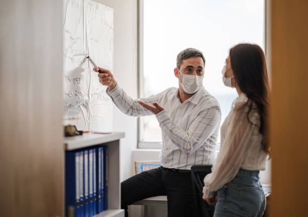 istock Business People With Protective Face Mask Discussing 1309776198