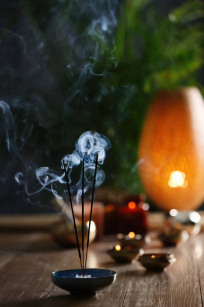 istock Incense sticks smoldering on wooden table in room 1309778519