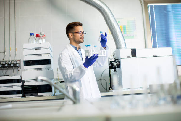 Young researcher workin with chemical samples in laboratory with HPLC system and  chromatography equipment Handsome young researcher workin with chemical samples in laboratory with HPLC system and  chromatography equipment chromatography stock pictures, royalty-free photos & images