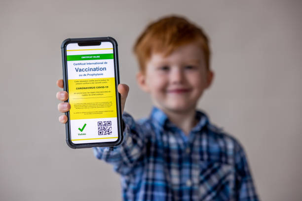 istock Vaccinated boy using digital vaccine passport app in mobile phone at customs for travel during Covid-19 pandemic 1309781075