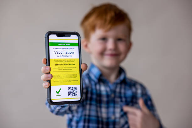 istock Vaccinated boy using digital vaccine passport app in mobile phone at customs for travel during Covid-19 pandemic 1309781296