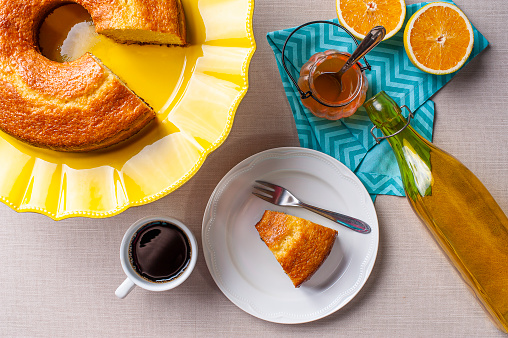 Homemade orange cake. Table with a piece of cake and cup of coffee. Top view