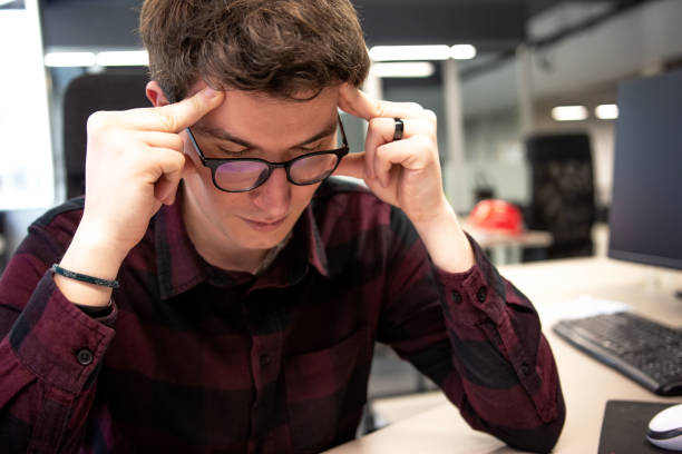 istock Tired businessman at workplace in office holding his head 1309784241