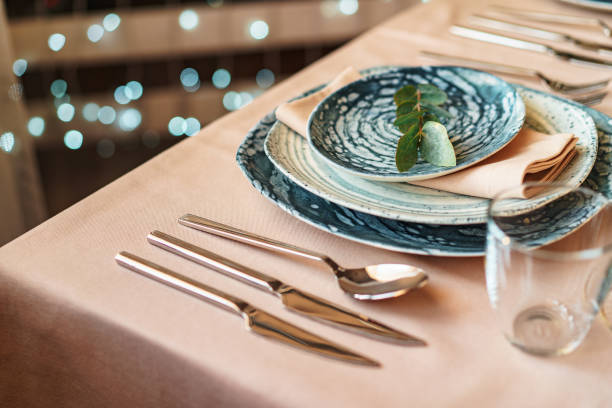 istock Beautiful elegant table setting with green stylish dishware and silver cutlery 1309784354