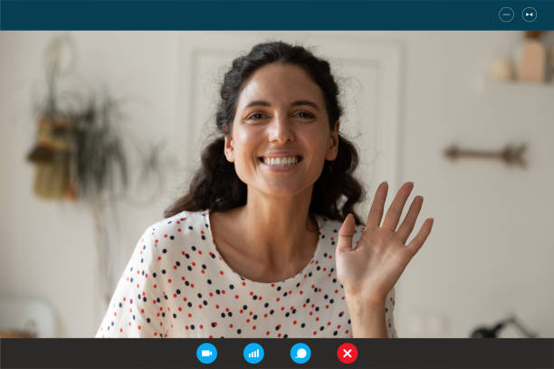 istock Smiling attractive woman waving hand at camera, starting video conversation. 1309784493
