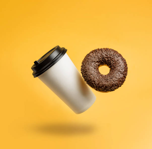 istock glass with coffee and a chocolate donut levitating against a yellow background 1309786213