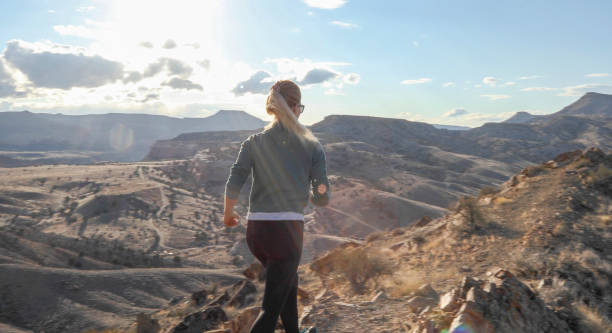 istock Female trail runner traverses mountain ridge in the morning 1309786537