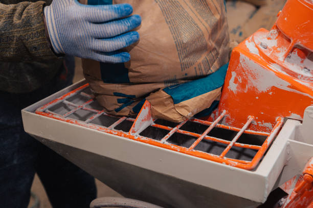istock A specialized mixer for mixing dry plaster with water and automatically feeding the finished plaster. A worker pours a bag of dry plaster into the hopper. 1309788049