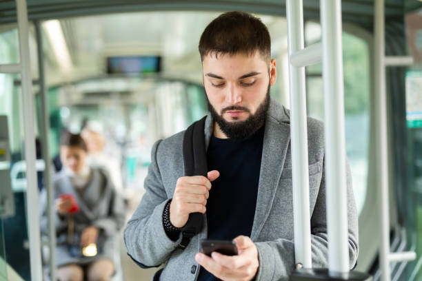 istock Portrait of male passenger using mobile phone in tram 1309789130
